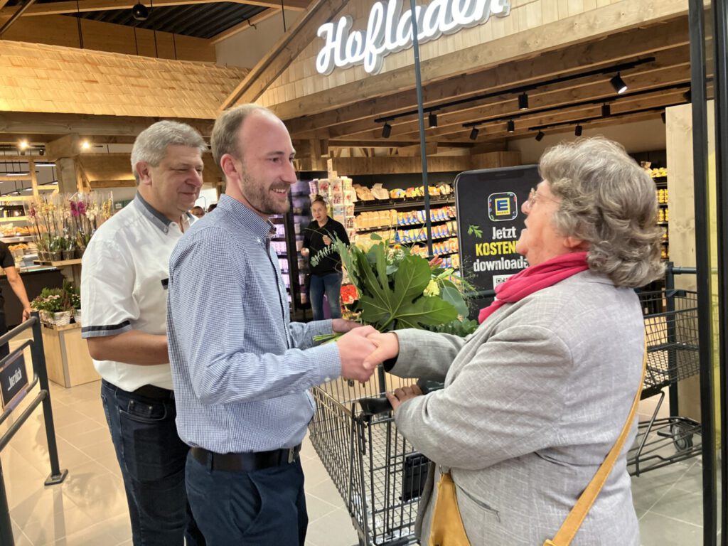 Bischofswerdaer Oberbürgermeister Prof. Dr. Holm Große und Betreiber des EDEKA-Markt Bischofswerda überreichen Blumenstrauß an die erste Kundin