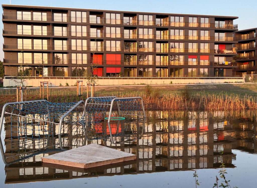 Überschwemmter Spielplatz und Blick auf das Gebäude MARINA GARDEN DRESDEN