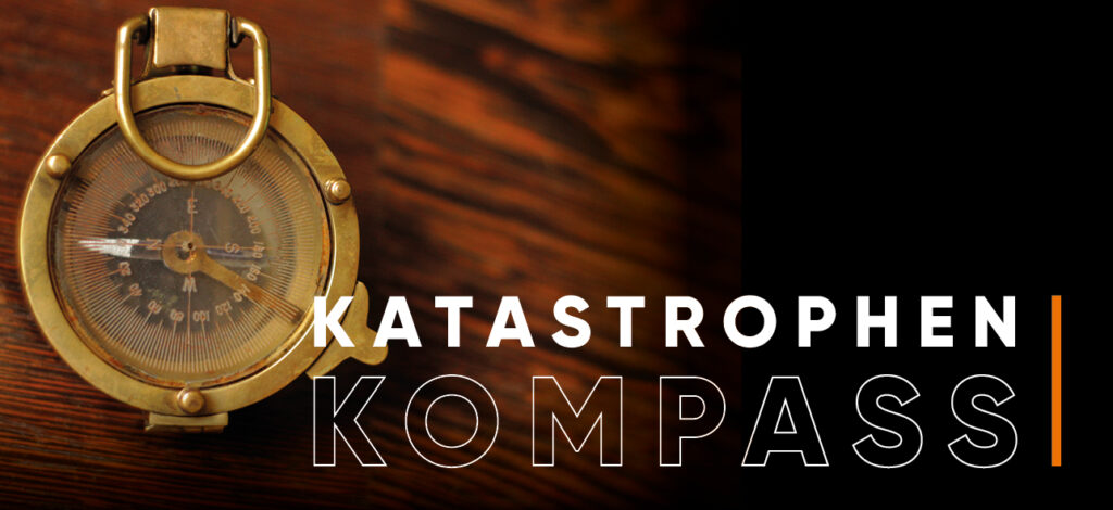 Katastrophenkompass - Bild eines Kompasses auf einem Holztisch